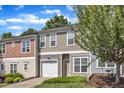 Attractive townhouse with green lawn, one-car garage, and tree in the front yard at 127 Deacon Ridge St, Wake Forest, NC 27587