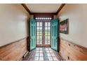 Inviting foyer with brick flooring, wood paneling, and teal double doors leading to the outside at 1706 Carthage St, Sanford, NC 27330