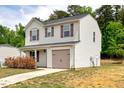 Side view of a two-story home with beige siding, purple shutters, and an attached garage at 1743 Longshadow Dr, Burlington, NC 27217