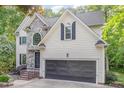 Charming two-story home with stone accents and attached two-car garage nestled among mature trees at 208 W Camden Forest Dr, Cary, NC 27518