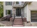 Inviting front entrance featuring a stone facade, brick steps, and a modern glass-paneled door at 208 W Camden Forest Dr, Cary, NC 27518