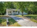 View of the house, showing the driveway and front yard surrounded by mature trees at 2108 Laurel Mill Centerville Rd, Louisburg, NC 27549