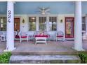 Charming front porch features cozy seating, creating an inviting outdoor living space with a blue ceiling at 224 E Park Dr, Raleigh, NC 27605