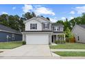 Beautiful two-story home featuring a two-car garage, attractive gray siding, and a well-maintained front lawn at 230 Purple Aster St St, Youngsville, NC 27596