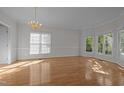 Inviting living room with abundant natural light from large windows, and polished hardwood floors at 2309 Clerestory Pl, Raleigh, NC 27615