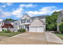 Charming two-story home features a two-car garage, blue shutters, and manicured lawn on a sunny day at 312 Grassy Point Rd, Apex, NC 27502