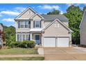 Charming two-story home features a two-car garage, blue shutters, and manicured lawn on a sunny day at 312 Grassy Point Rd, Apex, NC 27502