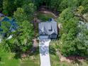 Aerial view of a home with a long driveway surrounded by lush trees and a well-maintained yard at 3627 River Watch Ln, Franklinton, NC 27525