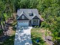 Aerial view of a home with a long driveway surrounded by lush trees and a well-maintained yard at 3627 River Watch Ln, Franklinton, NC 27525