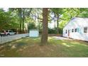 Spacious backyard featuring a storage shed, mature trees, and a white picket fence for added privacy at 409 Green St, Sanford, NC 27330