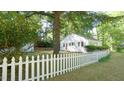 Charming white home featuring blue shutters and a quaint white picket fence at 409 Green St, Sanford, NC 27330