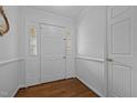 Bright foyer featuring a white paneled front door and classic wood flooring at 411 Westhampton Dr, Burlington, NC 27215