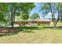 Brick house with front porch shaded by trees, nestled on a lush lawn at 4418 Carpenter Pond Rd, Durham, NC 27703