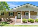 Inviting brick home with a welcoming front porch and well-maintained landscaping at 4418 Carpenter Pond Rd, Durham, NC 27703