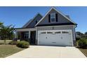 Charming two-story home with a manicured lawn, attached garage, and craftsman details at 47 Scarlet Bell Dr, Youngsville, NC 27596