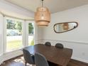 Warm dining room featuring a modern chandelier, dining table, and large windows at 4908 Birkenhead Ct, Apex, NC 27539