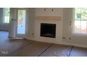 Bright living room showcasing a cozy fireplace, complemented by windows, and awaiting your personal touch at 499 Mulberry Rd, Spring Hope, NC 27882