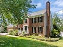 Charming two-story brick home with a chimney, professional landscaping, and black shutters at 5 Bobby Parker Pl, Durham, NC 27703