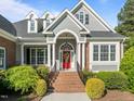 Close-up of a beautiful home featuring a red front door and well-manicured landscaping, creating a welcoming entrance at 503 Belmont Cir, Wake Forest, NC 27587