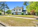 A two-story home has a brick-lined walkway leading to a charming front door, complemented by lush greenery at 506 S King Ave, Dunn, NC 28334