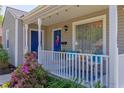 Cozy front porch featuring white railing, colorful landscaping, and comfortable seating with accent pillows at 508 E Trinity Ave, Durham, NC 27701