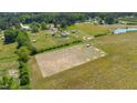 Aerial view of expansive land with a pasture area and a small pond on property at 5423 Nc-39, Selma, NC 27576