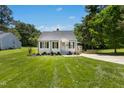 Beautiful one-story home featuring lush green lawn, complemented by mature trees and meticulous landscaping at 624 Wait Ave, Wake Forest, NC 27587
