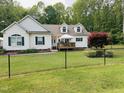 Inviting home featuring a charming front yard with well-manicured lawn and a black chain link fence at 67 Bull Run N, Timberlake, NC 27583
