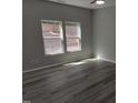 Bedroom featuring wood-look floors and a pair of windows overlooking the backyard at 7 Mint Hill Ct, Durham, NC 27703