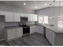 Modern kitchen with stainless steel appliances, granite countertops, white cabinets, and pendant lighting at 7 Mint Hill Ct, Durham, NC 27703