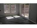 Bright living room with wood-look floors, large windows, and sliding glass door to the backyard at 7 Mint Hill Ct, Durham, NC 27703