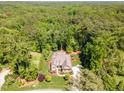 Aerial view of a brick home surrounded by mature trees and lush green landscaping at 7108 Carries Reach Way Way, Raleigh, NC 27614