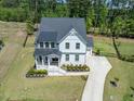 Aerial view of a two-story home featuring a well-manicured yard, and a long driveway at 7616 Hasentree Way, Wake Forest, NC 27587