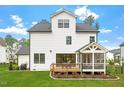 The home's back exterior has a wooden deck, a lawn, and is complimented by tasteful landscaping at 7616 Hasentree Way, Wake Forest, NC 27587