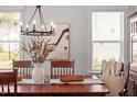 Elegant dining room features a wood table, chandelier, and natural light creating a warm and inviting ambiance at 7616 Hasentree Way, Wake Forest, NC 27587