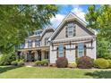 Expansive two-story home with a covered front porch and beautiful landscaping at 1012 Wandering Way, Rolesville, NC 27571