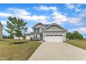 Charming two-story home with a two-car garage, light gray siding, and a well-manicured lawn at 1013 Fieldmere Pl, Wendell, NC 27591