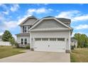 Charming two-story home with a two-car garage, light gray siding, and a well-manicured lawn at 1013 Fieldmere Pl, Wendell, NC 27591