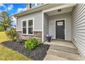 Inviting front entrance with a black door, stone accents, and manicured landscaping at 1013 Fieldmere Pl, Wendell, NC 27591