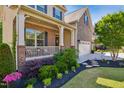 Landscaped front yard with lush plantings, a brick walkway, and inviting front porch for relaxing at 106 Mesquite Dr, Durham, NC 27703