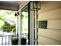 Close up of house number '1166' beside a modern outdoor light fixture, indicating the property's address at 1166 Nc Highway 87 N, Pittsboro, NC 27312
