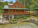 Log home featuring a porch, tiered landscaping with stone walls, and a natural setting at 123 Beech Forest Way, Pittsboro, NC 27312