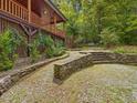 Stone steps leading to a wooden gate, framed by lush greenery and a wooded area at 123 Beech Forest Way, Pittsboro, NC 27312