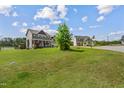 Well-maintained home with a lush green lawn, surrounded by trees in a Gathering-friendly neighborhood at 123 Hawick Ct, Zebulon, NC 27597