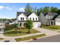 A two-story home featuring a two-car garage and a covered porch with a comfortable seating area at 128 Highland Grove Way, Fuquay Varina, NC 27526