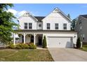 Charming two-story home with a white exterior, front porch, and well-maintained lawn and landscaping at 128 Highland Grove Way, Fuquay Varina, NC 27526