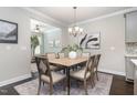 Dining room with hardwood floors, stylish light fixtures and adjacent living spaces at 1314 Catch Fly Ln, Durham, NC 27713