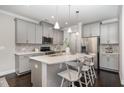 Modern kitchen featuring gray cabinets, quartz countertops, stainless steel appliances, and a kitchen island at 1314 Catch Fly Ln, Durham, NC 27713