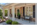 Inviting covered porch with brick flooring and benches, perfect for relaxing outdoors at 1401 Marshall Farm St, Wake Forest, NC 27587