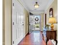 Welcoming foyer with hardwood floors, coat closet, and decorative table with mirror accent at 1410 Osborne Dr, Burlington, NC 27215